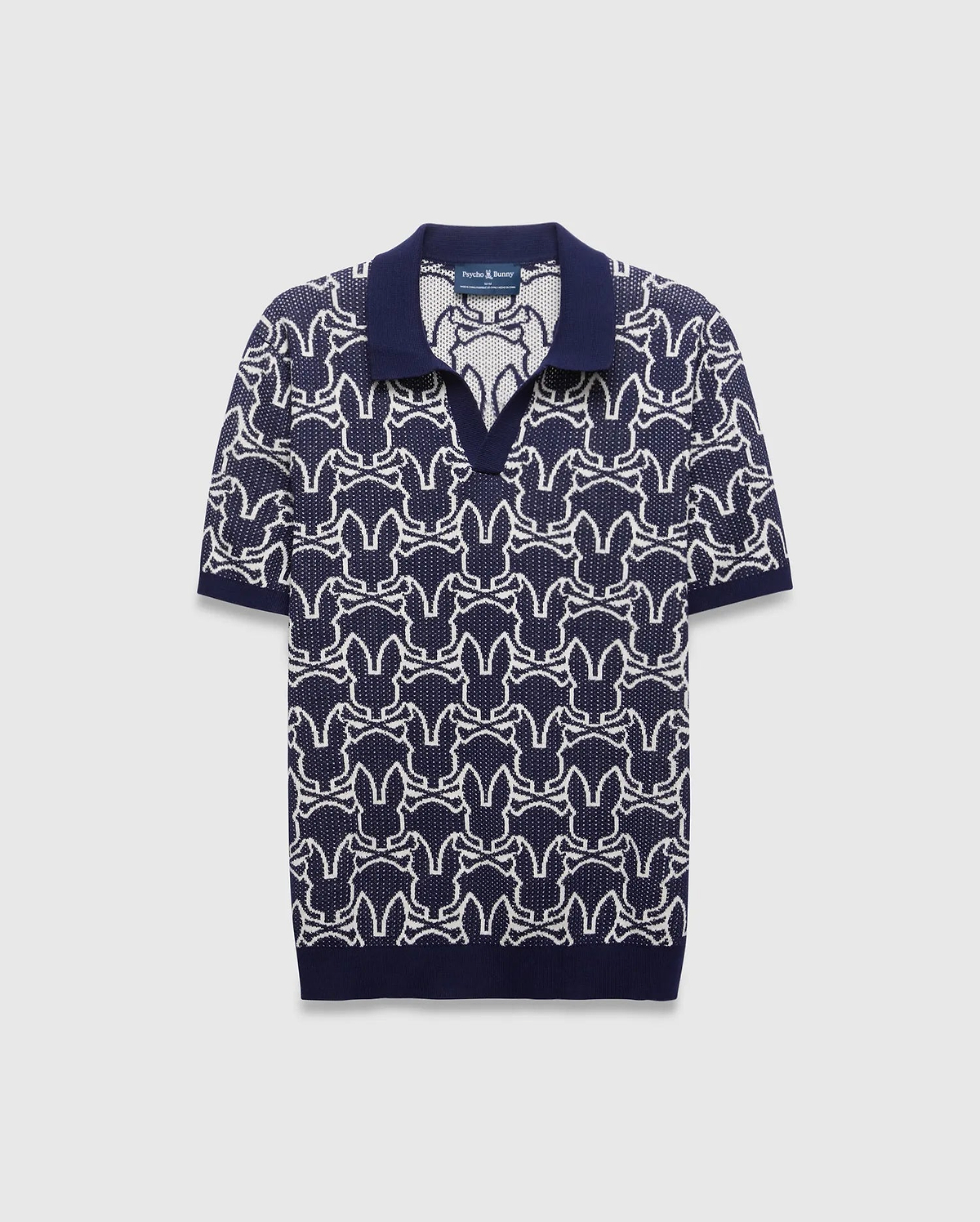Mens Sidney Oversized Knit Polo in navy with a striking all-over white Psycho Bunny skull logo pattern, featuring a refined knit texture and classic collar.