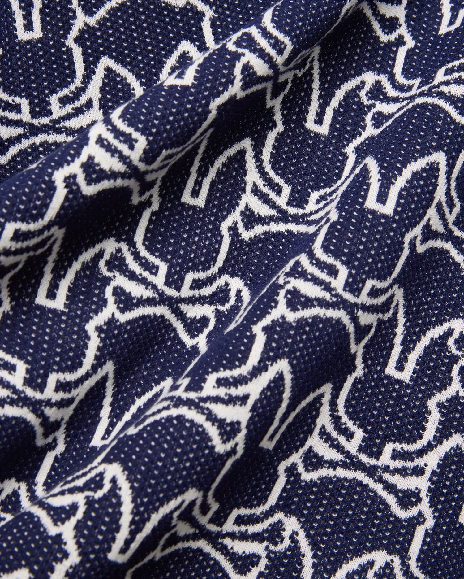 Mens Sidney Oversized Knit Polo in deep navy, featuring an all-over white outline Psycho Bunny skull logo pattern on a fine, textured knit fabric, offering a relaxed fit.