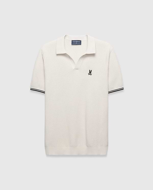 Cream Mens Selby Knit Polo featuring a unique textured knit fabric, open collar, small black embroidered Psycho Bunny skull logo on the left chest, and ribbed cuffs with black double stripes.