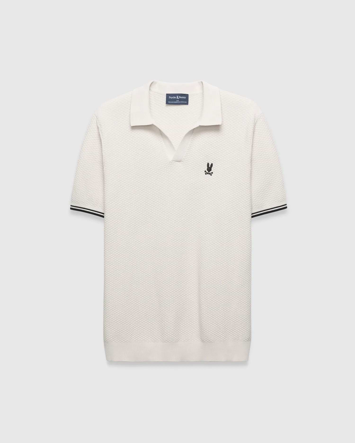 Cream Mens Selby Knit Polo featuring a unique textured knit fabric, open collar, small black embroidered Psycho Bunny skull logo on the left chest, and ribbed cuffs with black double stripes.