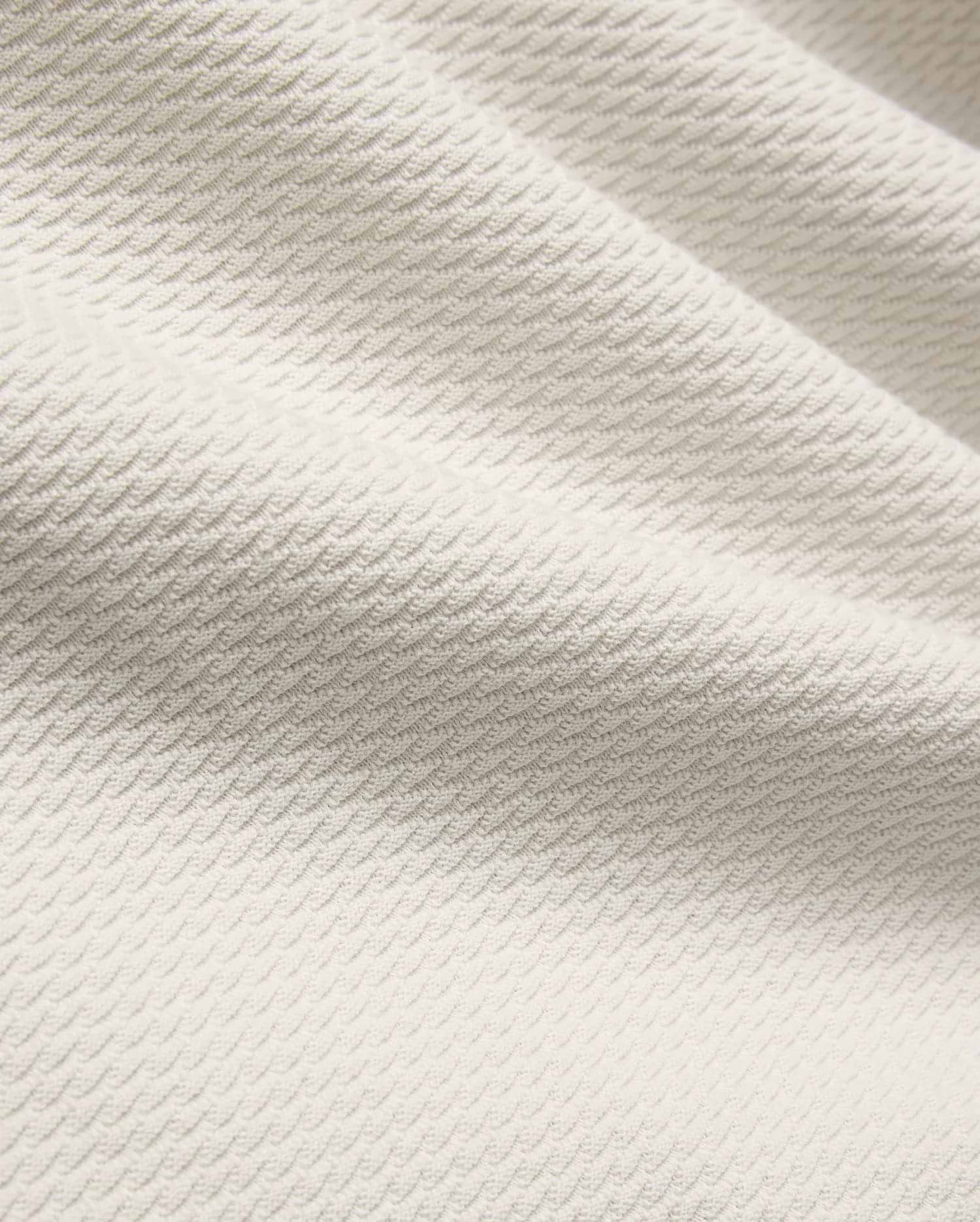 Mens Selby Knit Polo in a light cream hue, showcasing a premium textured knit fabric with a distinctive, subtle wave pattern, embodying refined streetwear style.
