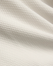 Mens Selby Knit Polo in a light cream hue, showcasing a premium textured knit fabric with a distinctive, subtle wave pattern, embodying refined streetwear style.