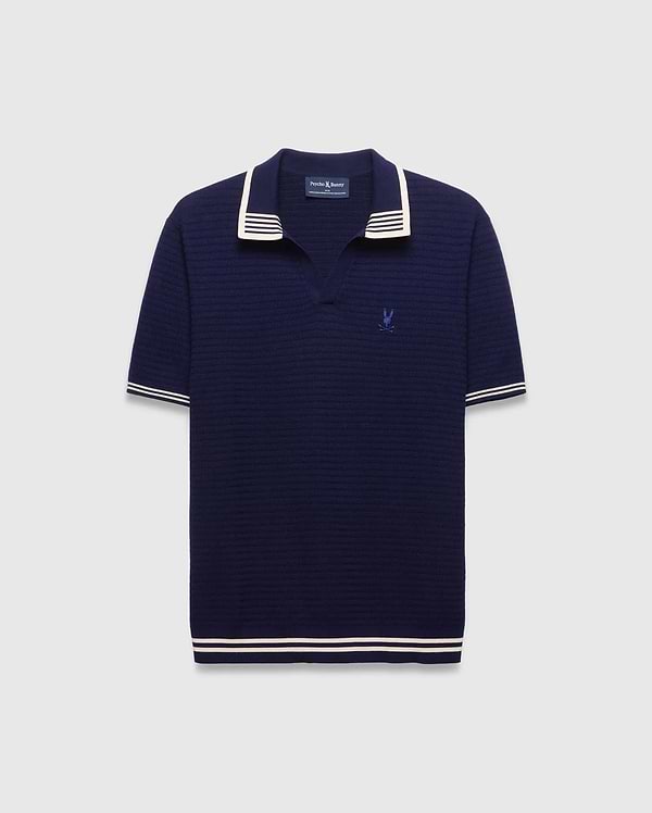 Mens Elowen Knit Polo in navy, featuring a textured knit fabric, white striped collar, cuffs, and hem, with a small embroidered Psycho Bunny skull logo on the left chest.