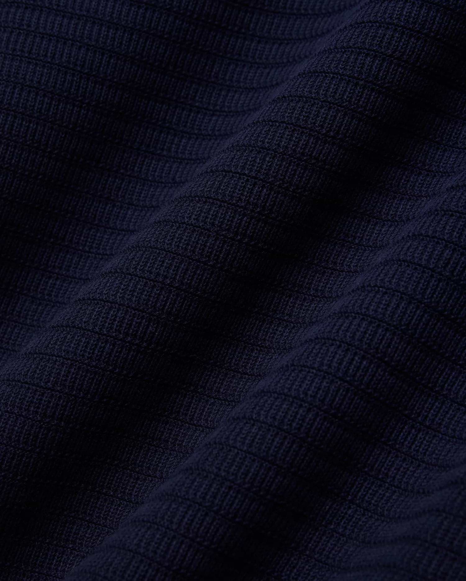 MENS ELOWEN KNIT POLO in deep navy blue, showcasing a finely crafted, horizontally ribbed knit texture with a soft, luxurious feel, characteristic of premium Psycho Bunny apparel.