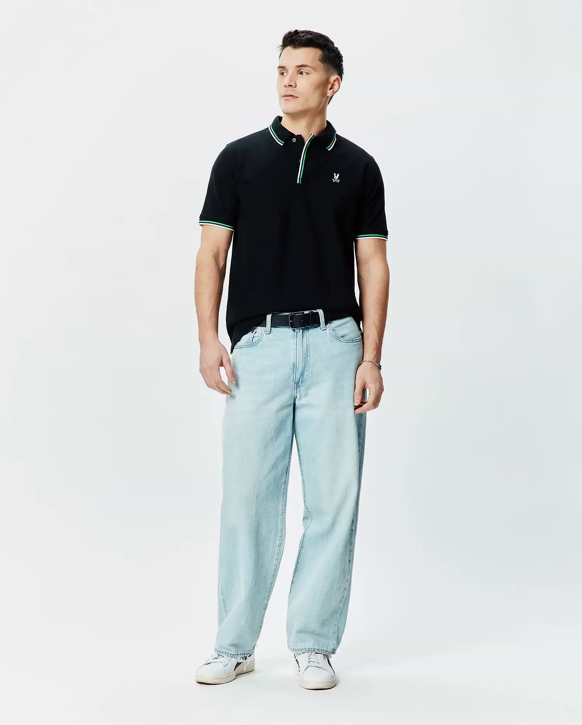 Mens Faye Pique Polo, black classic fit with green and white tipped collar and cuffs, featuring a small embroidered Psycho Bunny skull logo on the left chest.