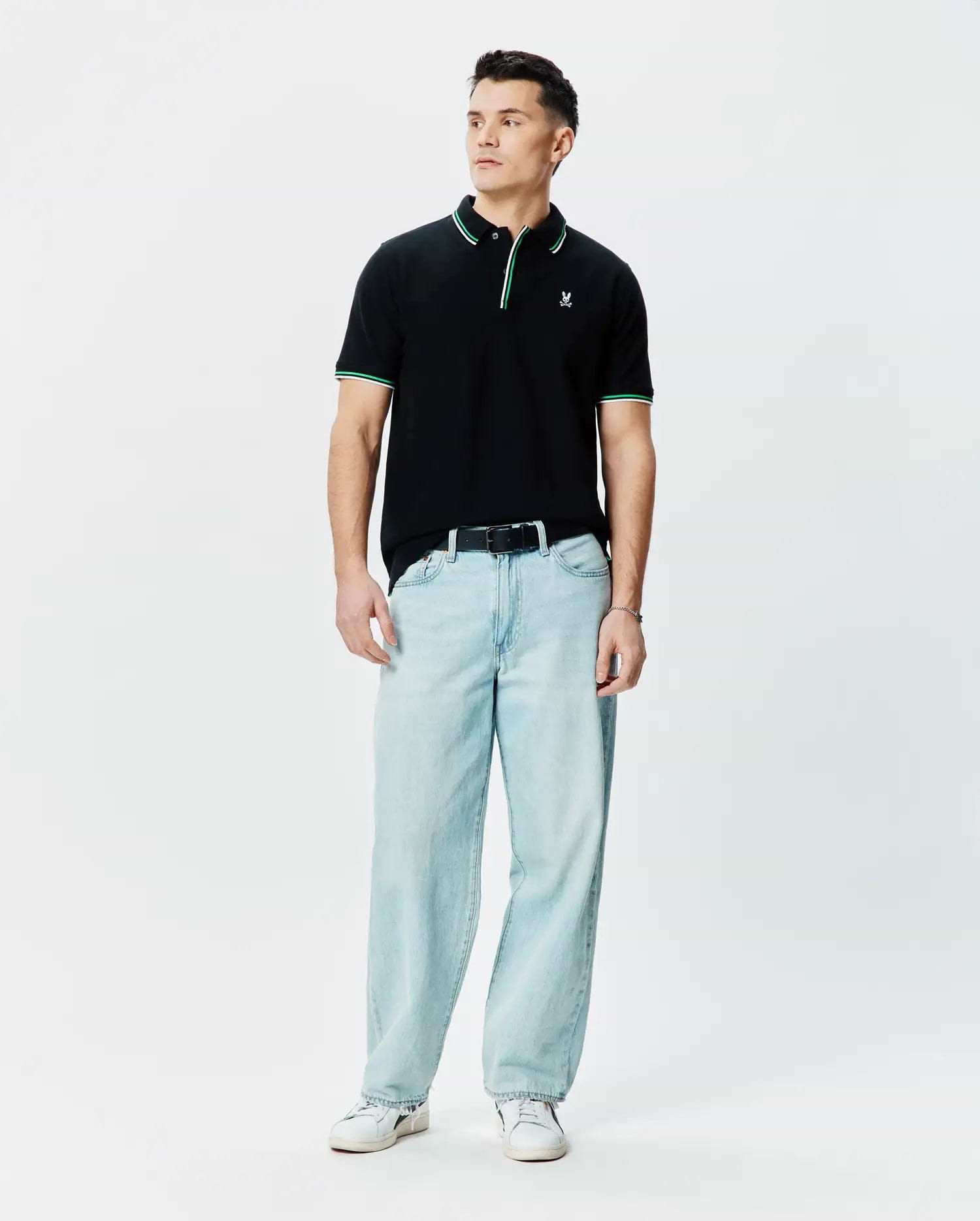 Mens Faye Pique Polo, black classic fit with green and white tipped collar and cuffs, featuring a small embroidered Psycho Bunny skull logo on the left chest.