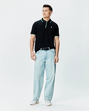 Mens Faye Pique Polo, black classic fit with green and white tipped collar and cuffs, featuring a small embroidered Psycho Bunny skull logo on the left chest.