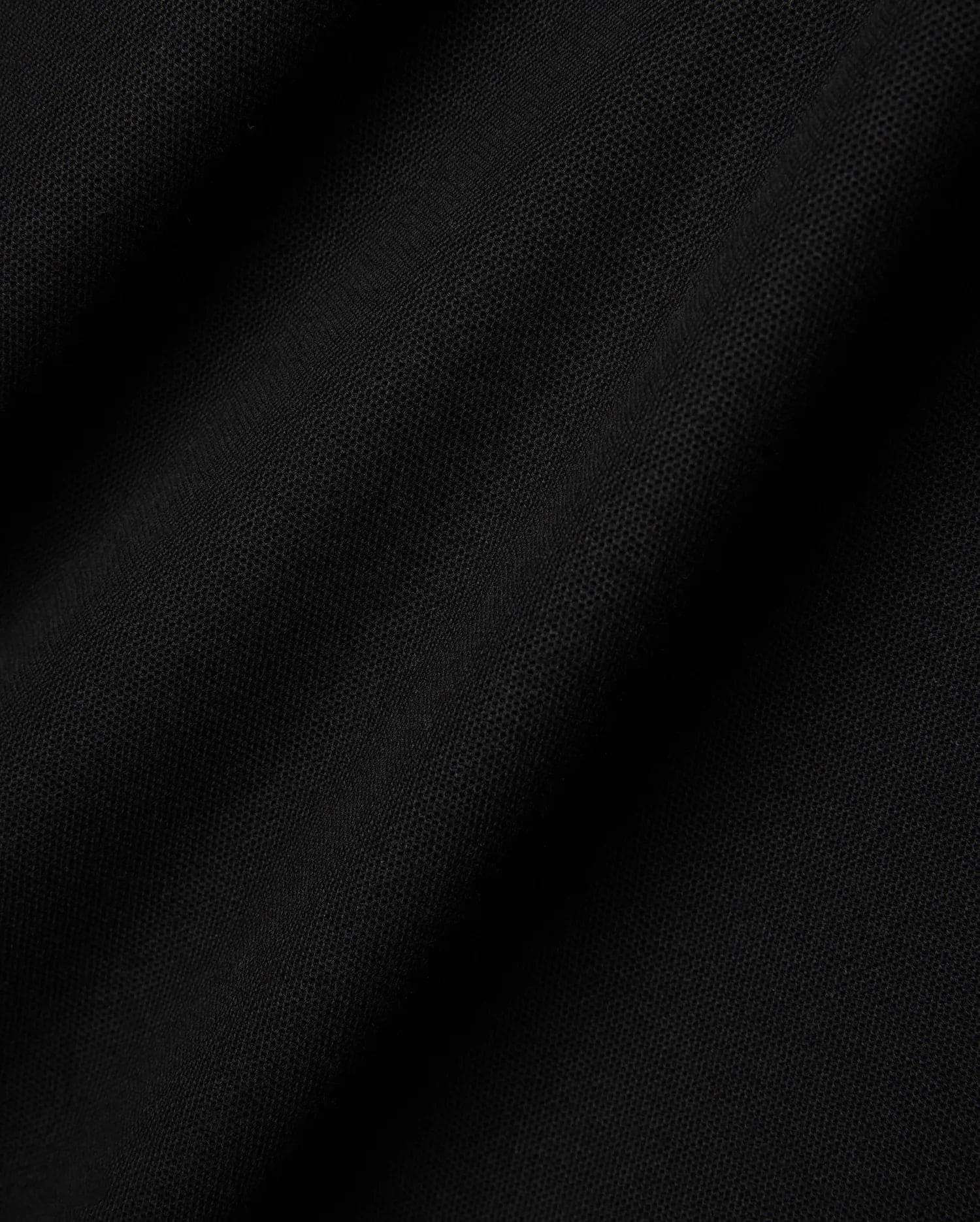 Mens Faye Pique Polo in a rich, deep black, showcasing the refined, breathable textured pique fabric with subtle folds and shadows, emphasizing its premium quality and classic weave.