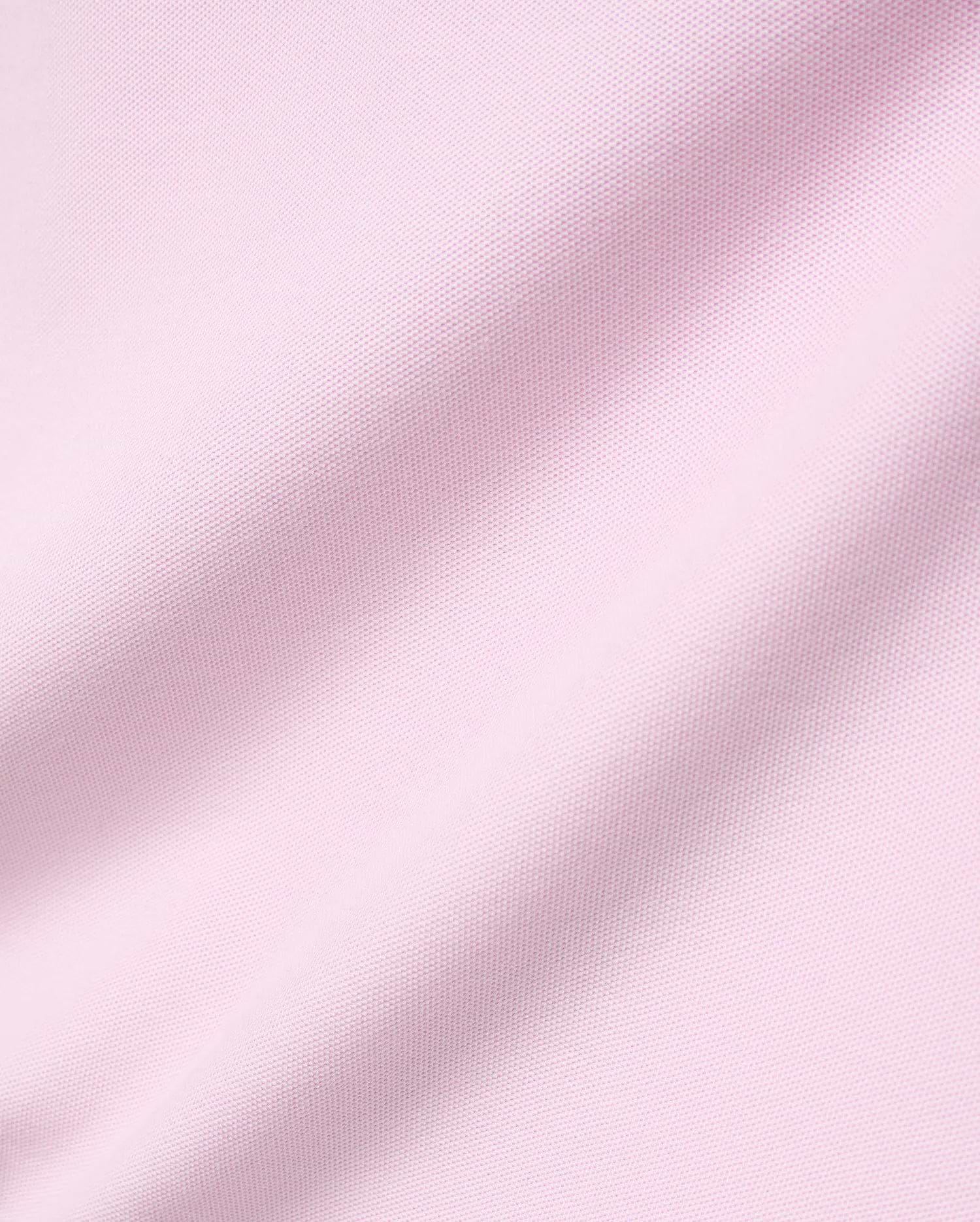 Mens Faye Pique Polo in a soft light pink, featuring a refined, classic pique knit fabric texture with gentle drapes, embodying premium Psycho Bunny style.