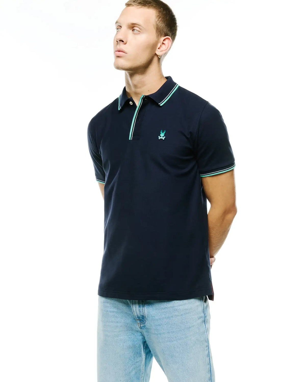 Men's Slade Pique Polo in navy, featuring a classic fit, pique knit texture, and a small embroidered mint green Psycho Bunny skull logo on the left chest. Accentuated with mint green and white striped collar and sleeve cuffs. (3)