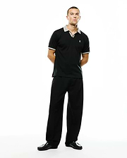 Black Men's Teddy Johnny Collar Polo, classic fit, smooth jersey knit, with grey and white check collar and cuffs, red side slit detail, small white embroidered Psycho Bunny skull logo on left chest. (4)