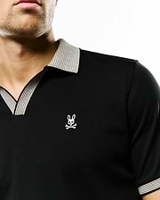Black jersey Men's Teddy Johnny Collar Polo with a classic fit, featuring a white textured Johnny collar, matching sleeve trim, and a small embroidered Psycho Bunny skull logo on the left chest. (2)
