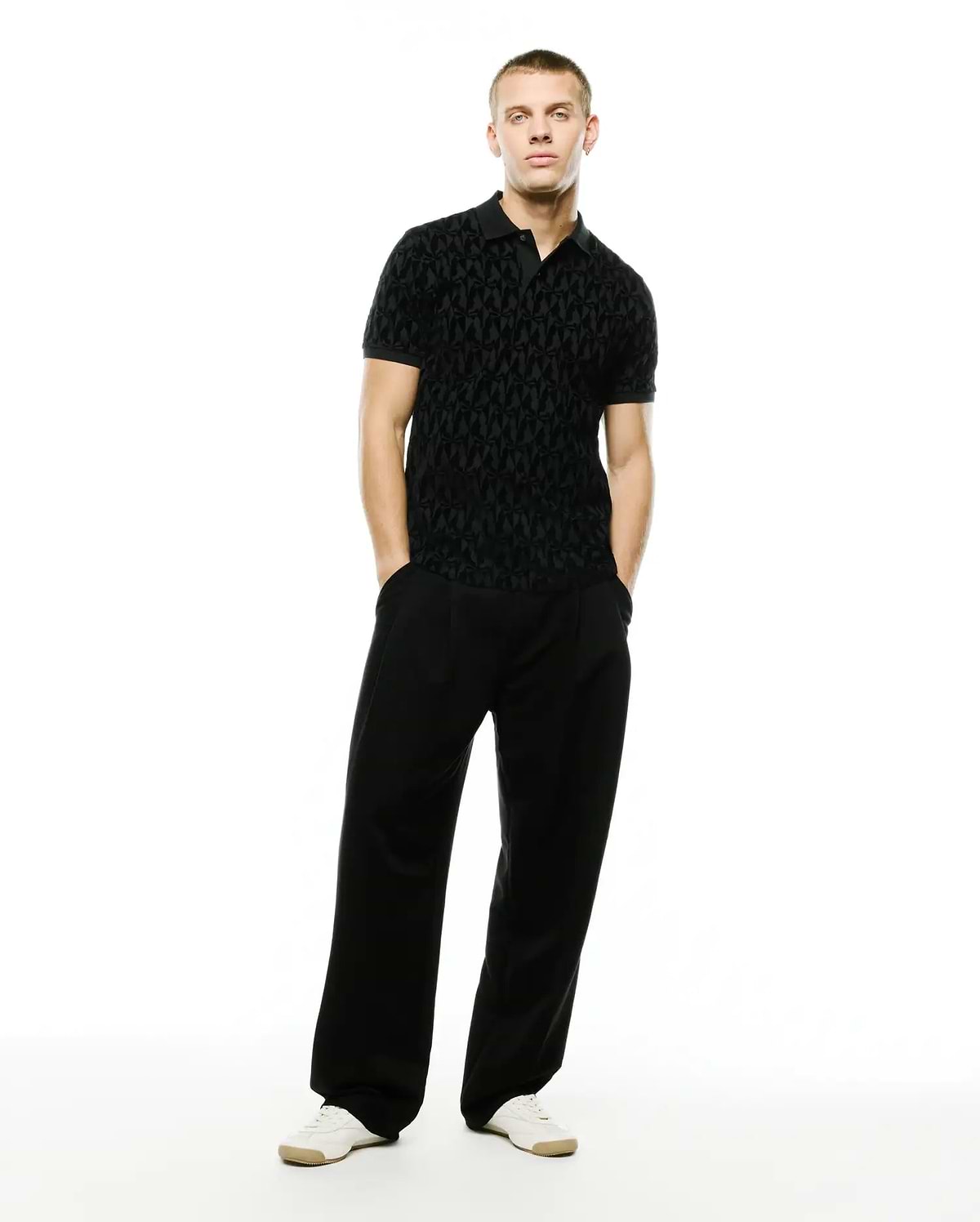 Men's Angus Flocked Polo: Black classic fit pique polo with a refined streetwear aesthetic, showcasing an all-over tonal flocked geometric bunny skull pattern and a two-button placket. (4)