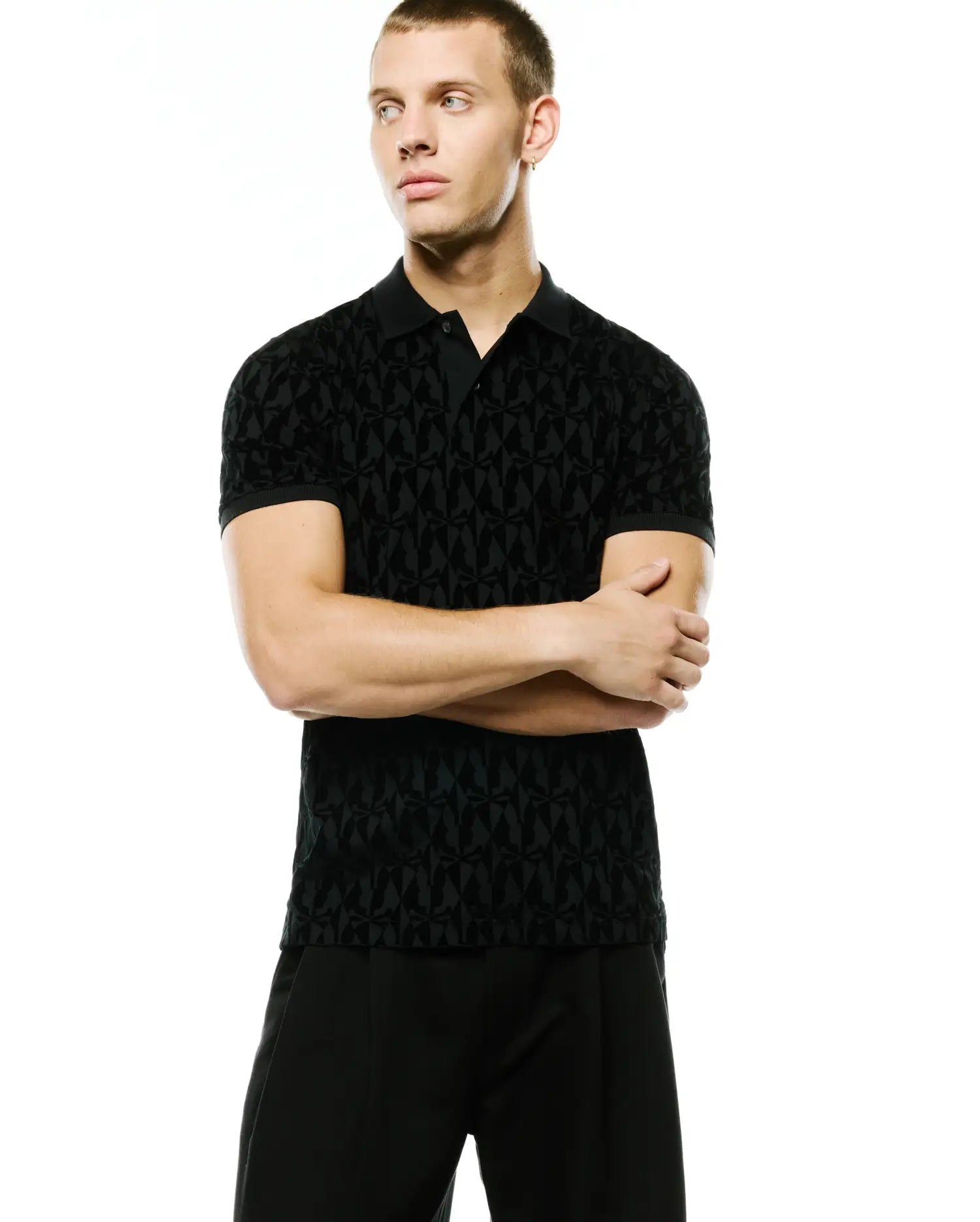 Men's Angus Flocked Polo, a black slim-fit jersey polo with a subtle all-over tonal flocked geometric pattern of the iconic Psycho Bunny skull, featuring a classic collar and two-button placket. (1)