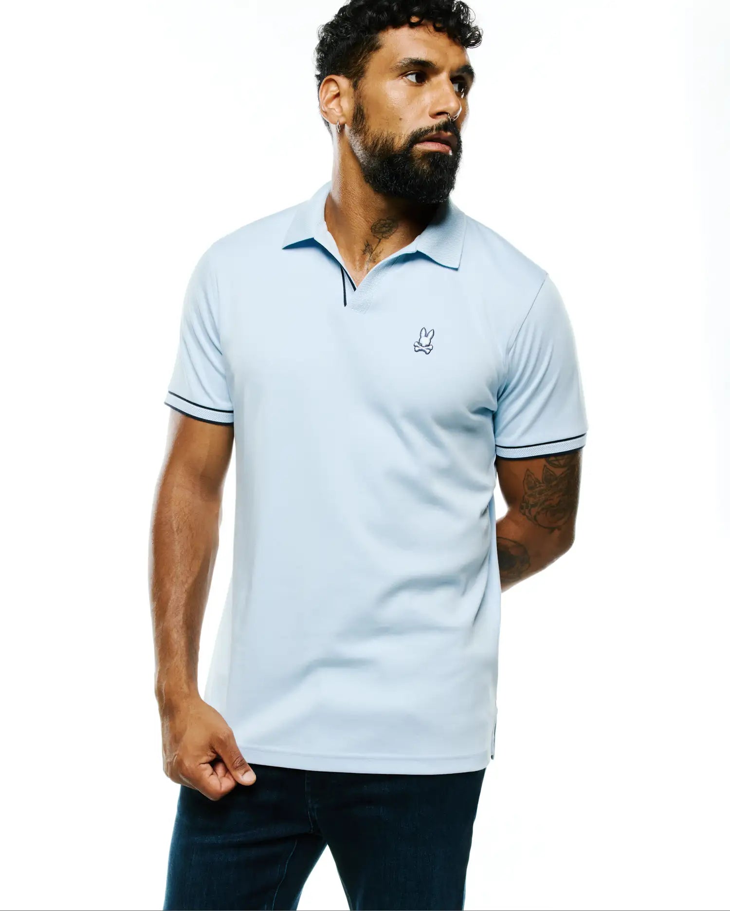 Light blue Mens Nasser Pima Johnny Polo in smooth Pima cotton, featuring navy tipping on the collar and sleeve cuffs, with a small embroidered Psycho Bunny skull logo on the left chest for a classic fit.