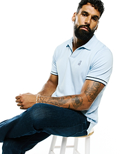 Mens Nasser Pima Johnny Polo, a light blue classic fit pique knit polo with a two-button placket, dark blue striped trim on collar and cuffs, and a small embroidered Psycho Bunny skull logo on the left chest.
