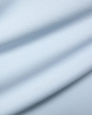 Mens Nasser Interlock Johnny Collar Polo, featuring a close-up of its soft, light blue interlock knit fabric with subtle texture and elegant draped folds.