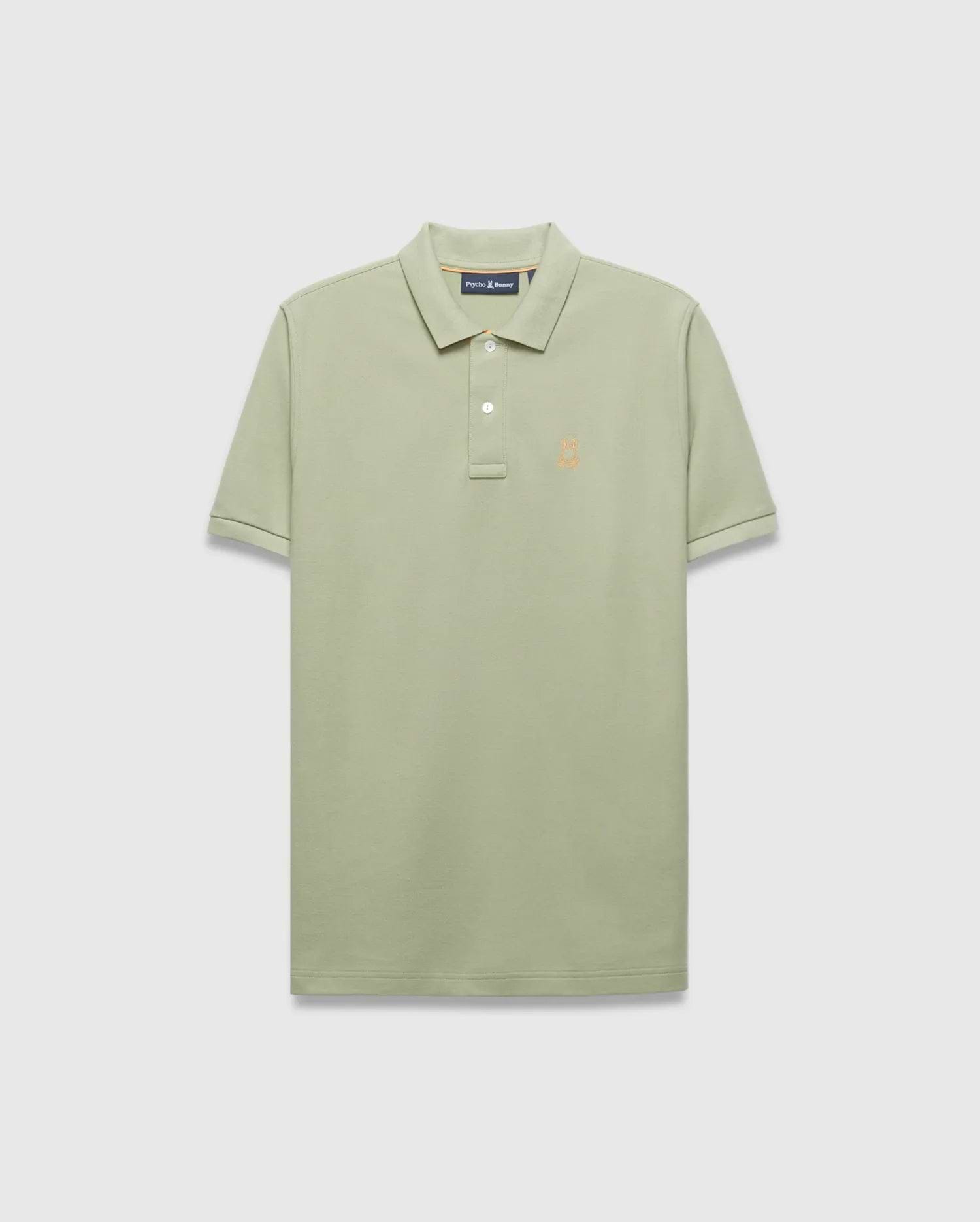 Mens Blythe Pique Polo in sage green, a classic fit polo with textured pique fabric, two-button placket, and a small embroidered orange Psycho Bunny skull logo on the left chest.