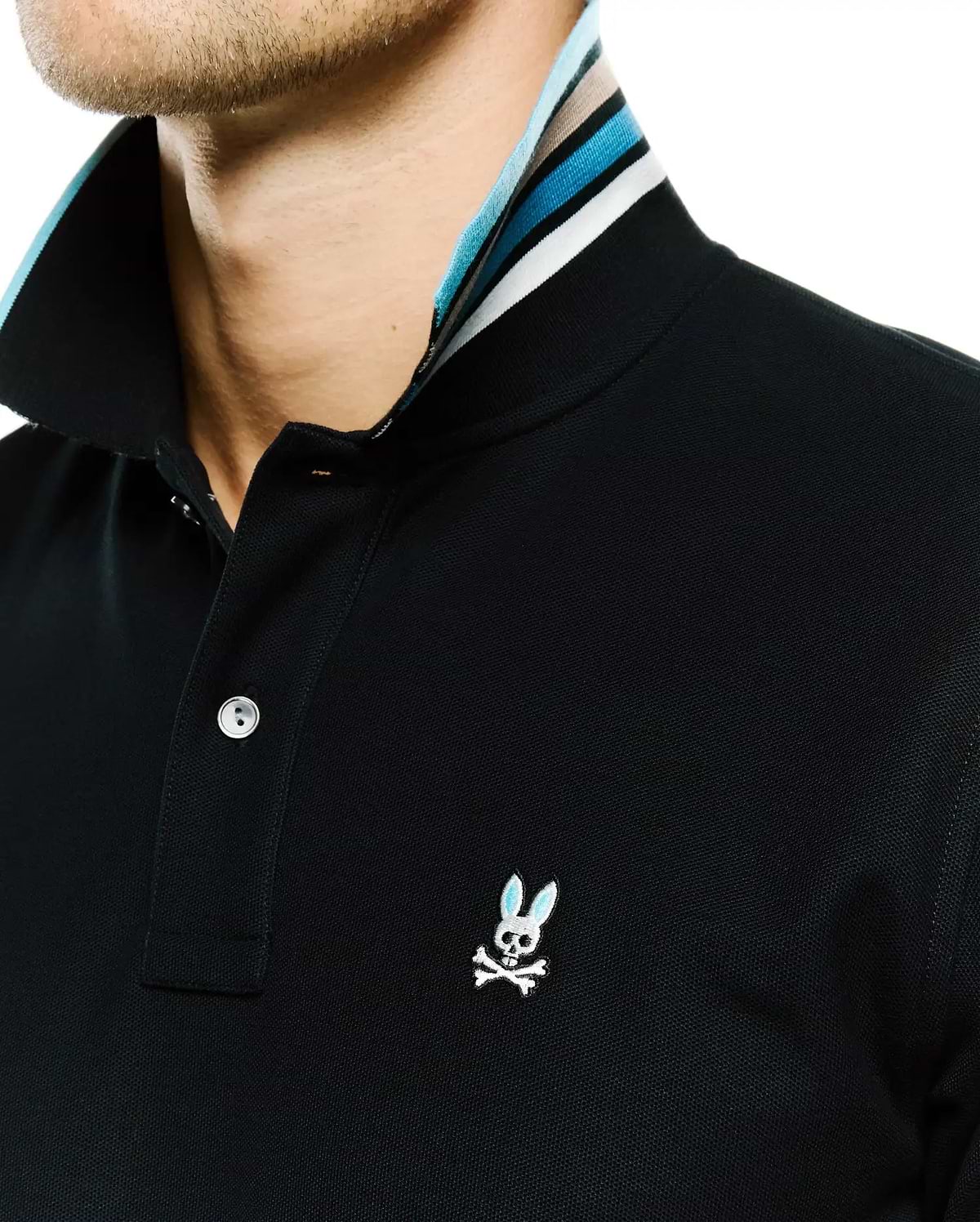 Men's Klaus Pique Polo, black classic fit pique polo with a striped collar featuring light blue, white, and beige, and an embroidered Psycho Bunny skull logo with light blue ears on the left chest. (2)