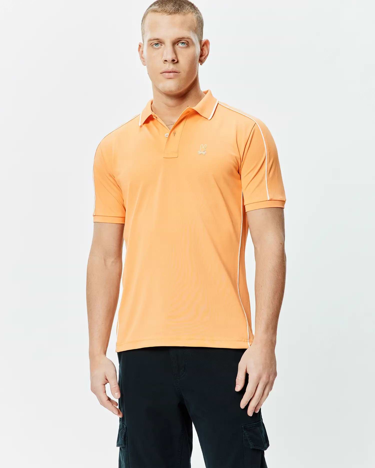 Mens Rhys Sport Polo, vibrant orange smooth performance jersey with white piping on shoulders and sides, classic fit, and small embroidered Psycho Bunny skull logo on left chest.