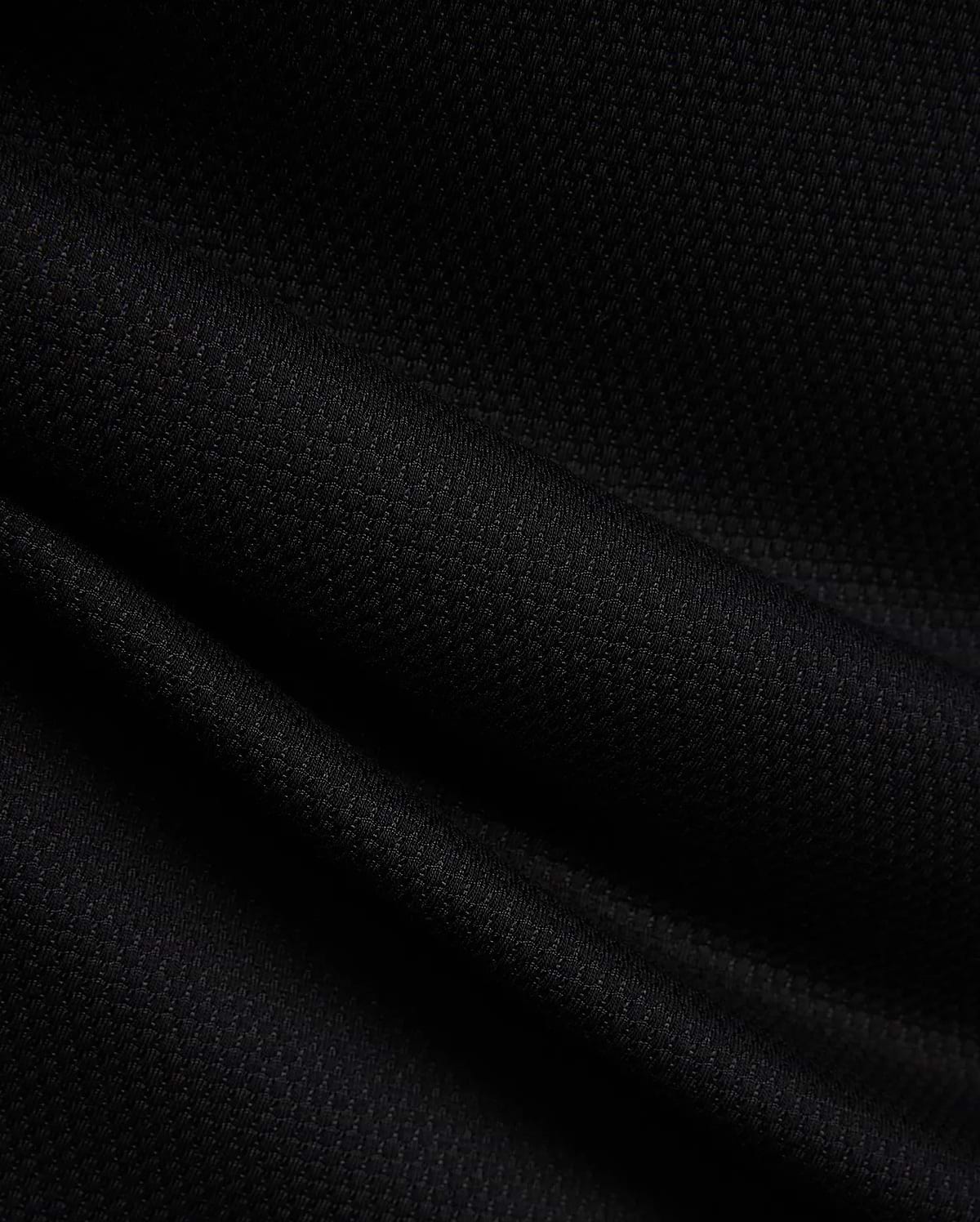 MENS TIERNAN PIQUE POLO in deep black, showcasing its premium, classic textured pique knit fabric with elegant folds, reflecting Psycho Bunny's refined streetwear aesthetic.