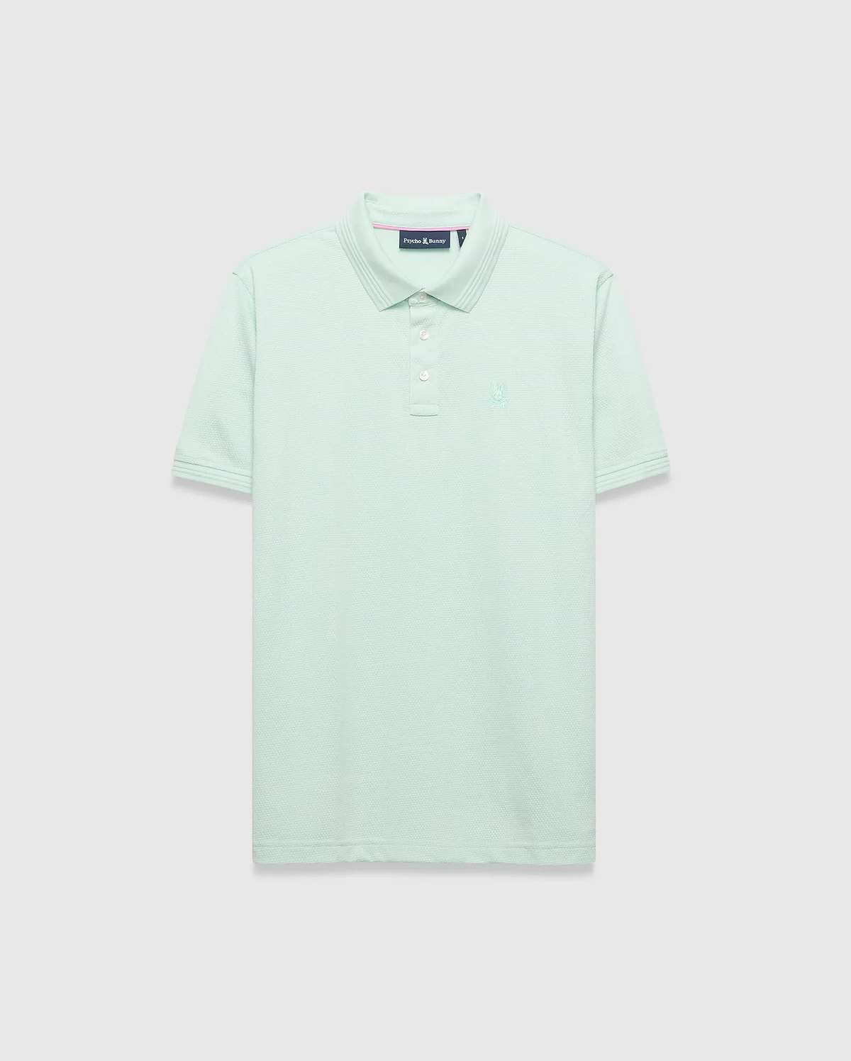 Mens Tiernan Pique Polo in mint green, featuring a classic fit, pique knit texture, ribbed collar and cuffs with subtle stripe detail, three white button placket, and a small tonal embroidered Psycho Bunny skull logo on the left chest.