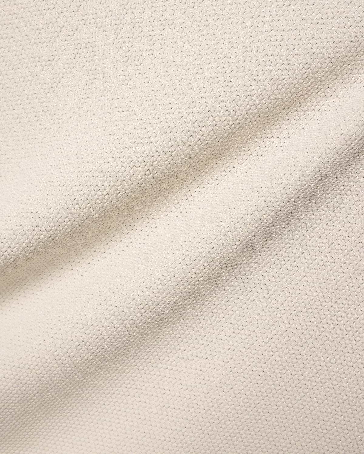 Mens Tiernan Pique Polo in a luxurious cream-colored pique fabric, featuring a refined textured weave and subtle folds, embodying Psycho Bunny's premium streetwear aesthetic.