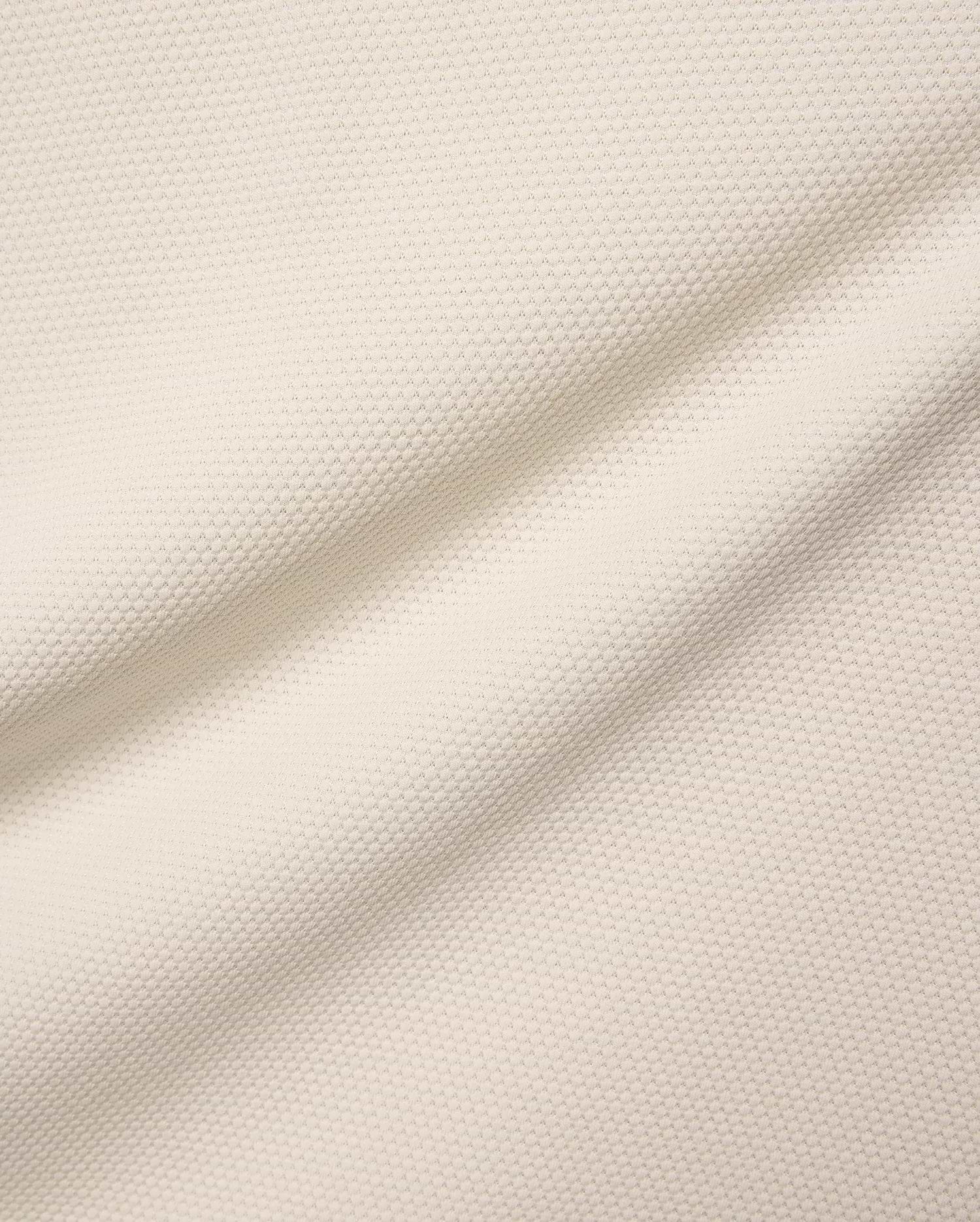 Mens Tiernan Pique Polo in a luxurious cream-colored pique fabric, featuring a refined textured weave and subtle folds, embodying Psycho Bunny's premium streetwear aesthetic.