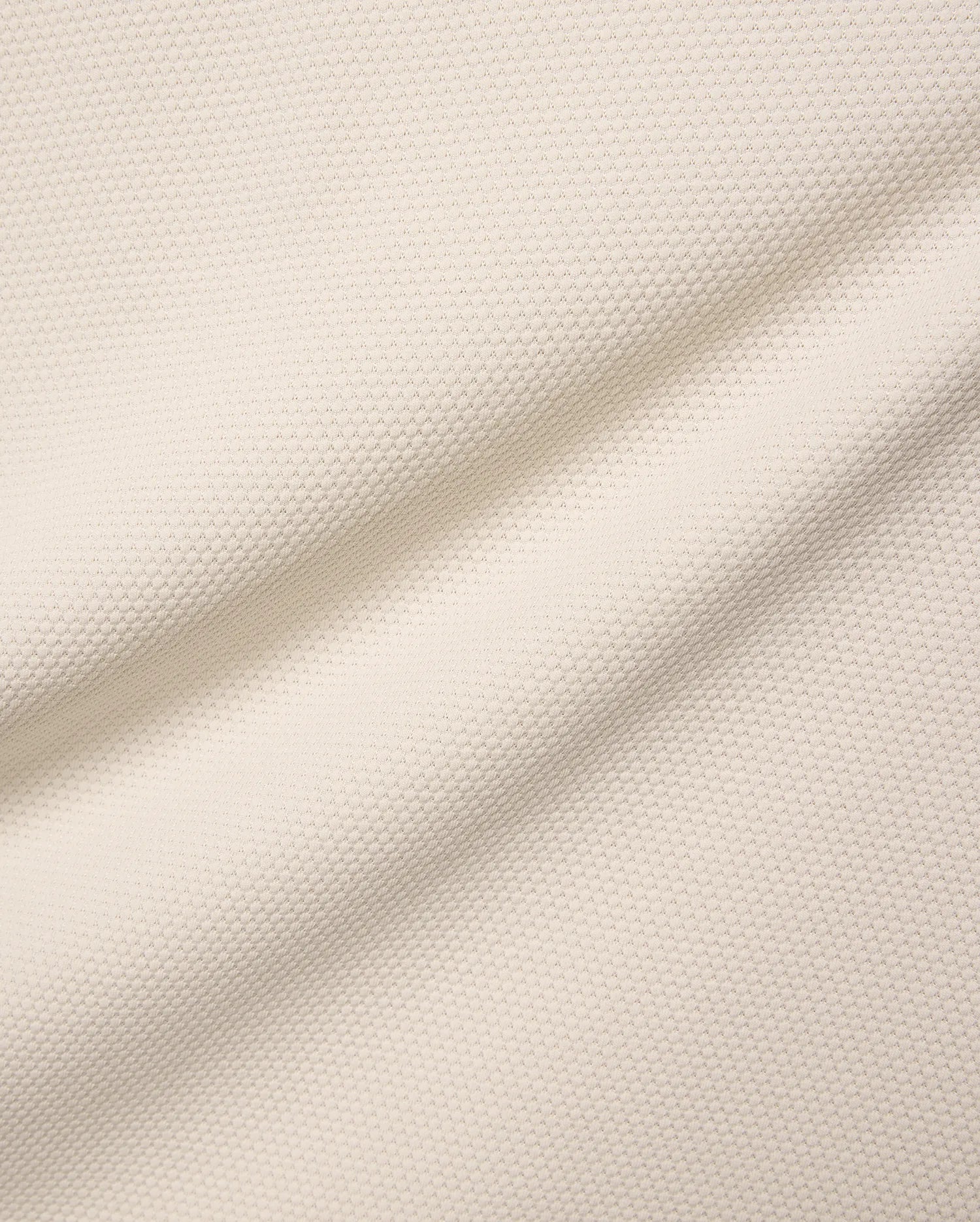 Mens Tiernan Pique Polo in a luxurious cream-colored pique fabric, featuring a refined textured weave and subtle folds, embodying Psycho Bunny's premium streetwear aesthetic.