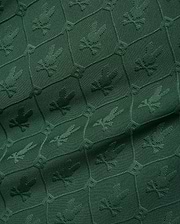 Mens Garry Jacquard Johnny Collar Polo in deep green, featuring an all-over tonal jacquard pattern of the iconic Psycho Bunny skull logo within a hexagonal grid. (9)