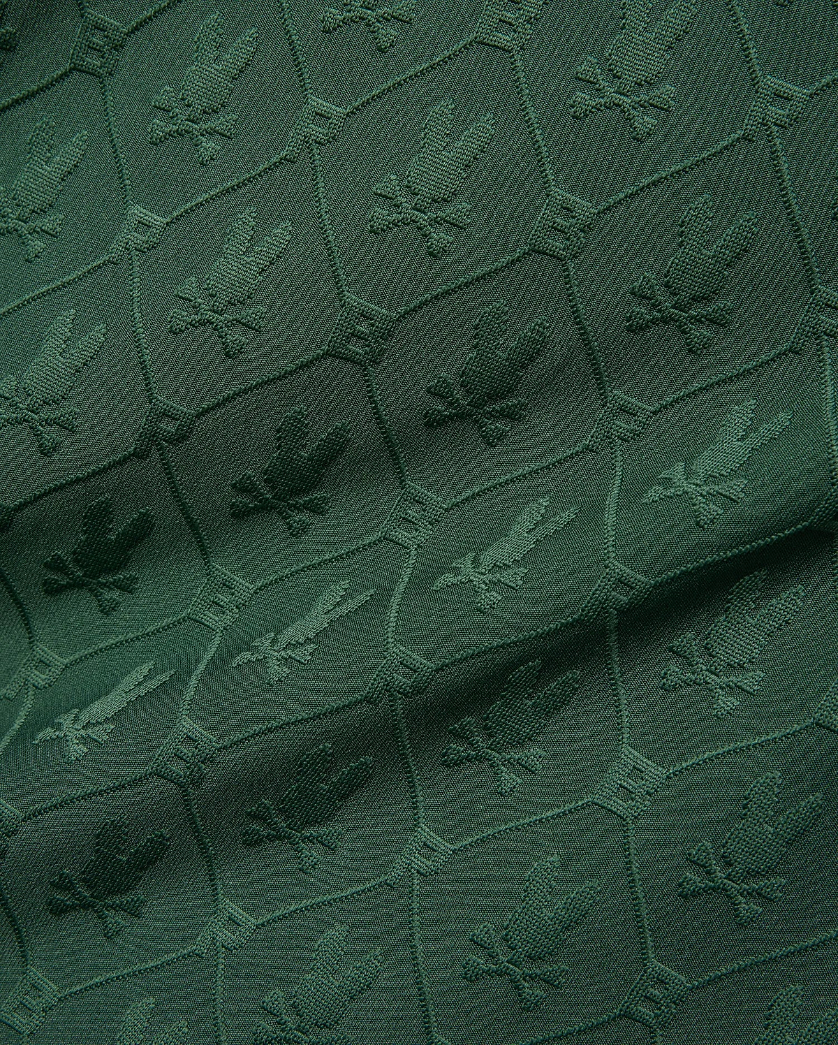 Mens Garry Jacquard Johnny Collar Polo in deep green, featuring an all-over tonal jacquard pattern of the iconic Psycho Bunny skull logo within a hexagonal grid. (9)