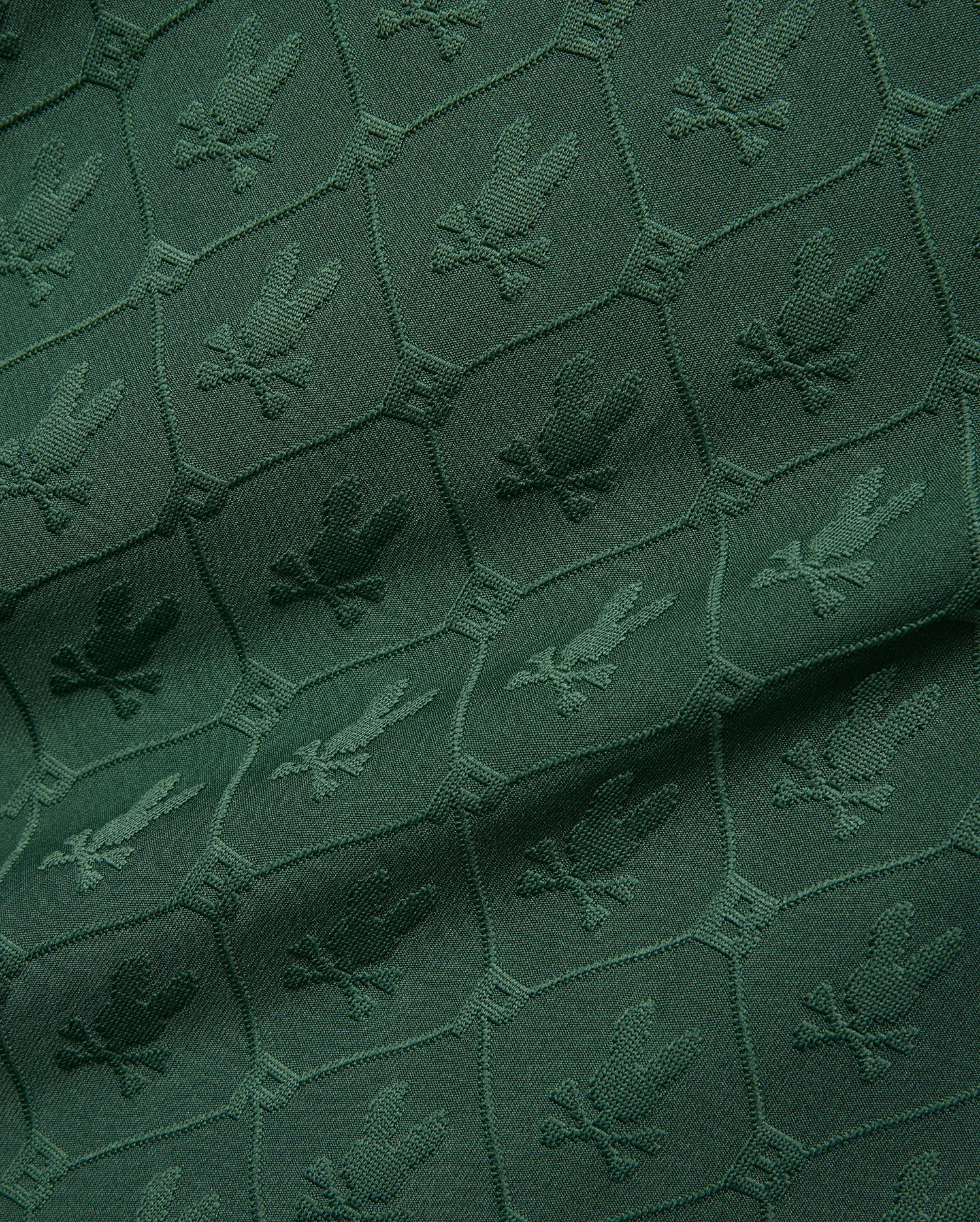 Mens Garry Jacquard Johnny Collar Polo in deep green, featuring an all-over tonal jacquard pattern of the iconic Psycho Bunny skull logo within a hexagonal grid. (9)