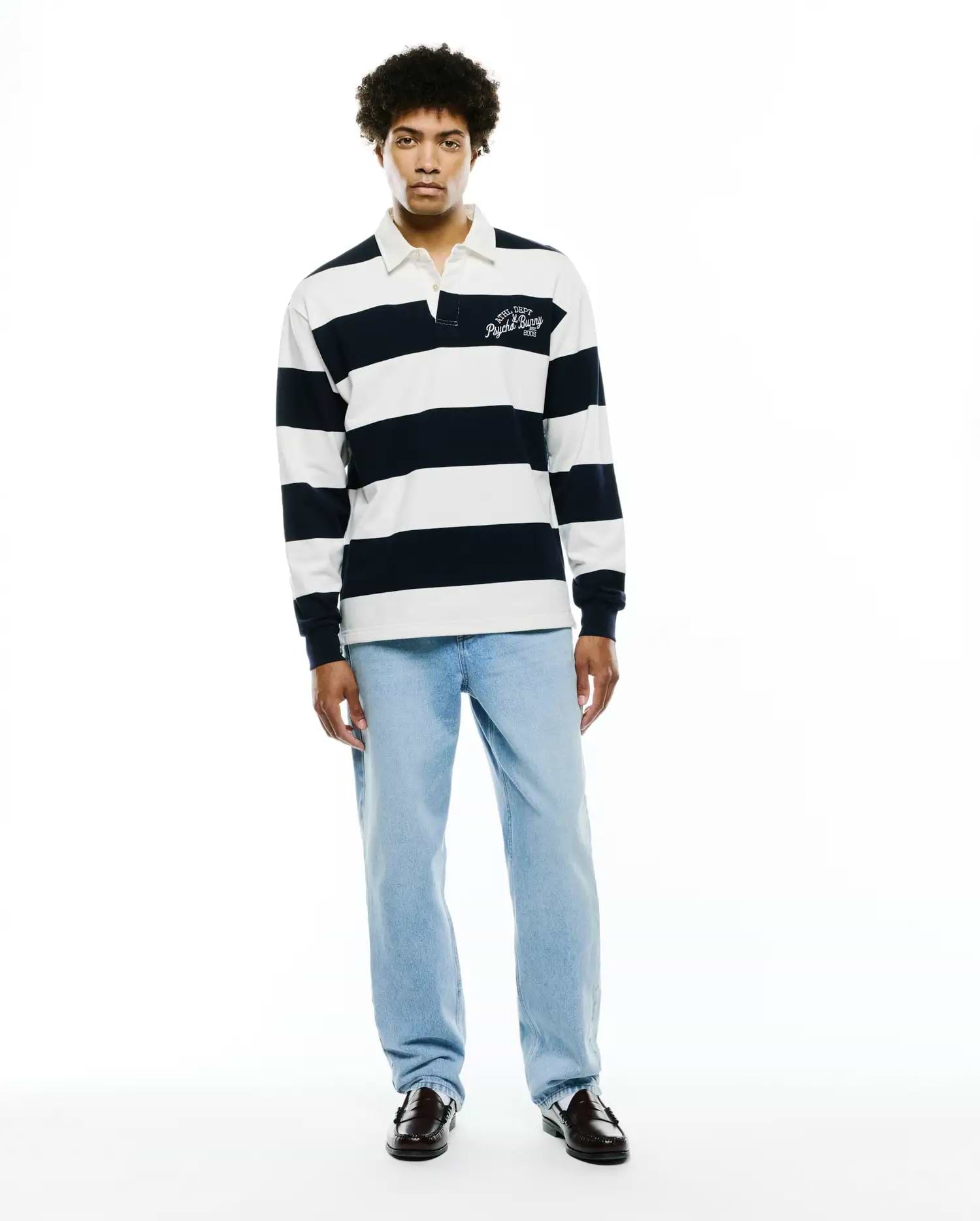 Mens Keven Ls Relaxed Fit Polo, a navy and white striped jersey knit with a white collar and an embroidered ATHL. DEPT Psycho Bunny EST. 2005 logo on the left chest. (6)