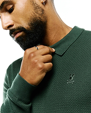 Mens Leroy Long Sleeve Knit Polo in deep forest green, featuring a textured knit fabric, ribbed collar and cuffs, and a small, tonal embroidered Psycho Bunny skull logo on the left chest. (2)