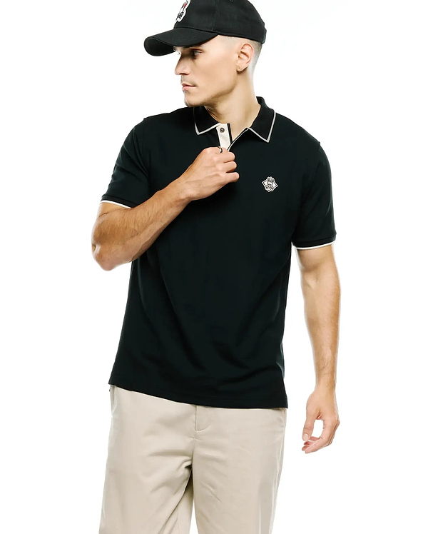 Mens Robin Pima Pique Polo, a classic fit black pique polo with white contrast tipping on the collar and cuffs, a light beige inner placket, and a small embroidered white Psycho Bunny skull logo on the left chest.
