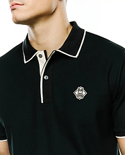 Mens Robin Pima Piqué Polo, a dark green pima pique polo with white tipped collar, placket, and cuffs, featuring an embroidered white Psycho Bunny skull logo on the left chest.