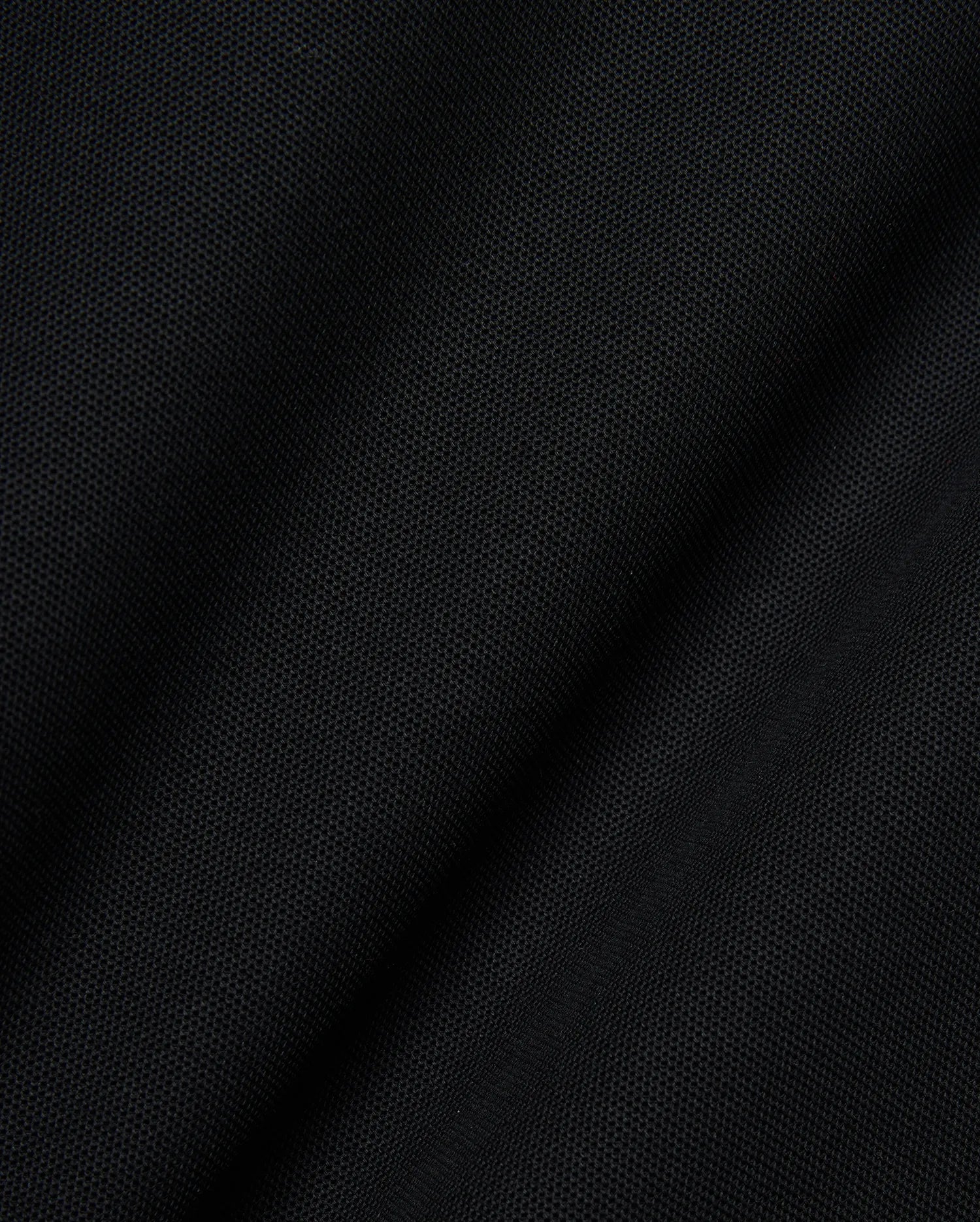 Mens Robin Pique Polo, a premium black pique knit fabric showcasing its distinctive textured weave and subtle drape, embodying Psycho Bunny's refined streetwear quality.