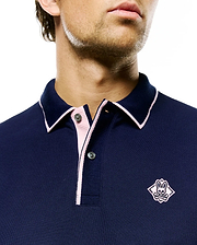 Mens Robin Pique Polo in navy pique knit, featuring a classic fit, pink contrast tipping on the collar and placket, and a pink embroidered Psycho Bunny skull logo on the left chest.