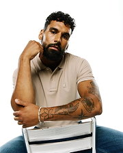 Mens Ringston Pique Polo in classic fit beige pique fabric, featuring a two-button placket, ribbed collar, white accent trim on the sleeves, and a small embroidered Psycho Bunny skull logo on the left chest.