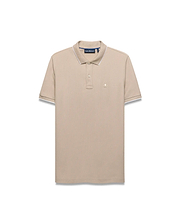 Mens Ringston Pique Polo in beige, featuring a classic fit, textured pique fabric, white tipping on the ribbed collar and cuffs, and a small embroidered Psycho Bunny skull logo on the left chest.
