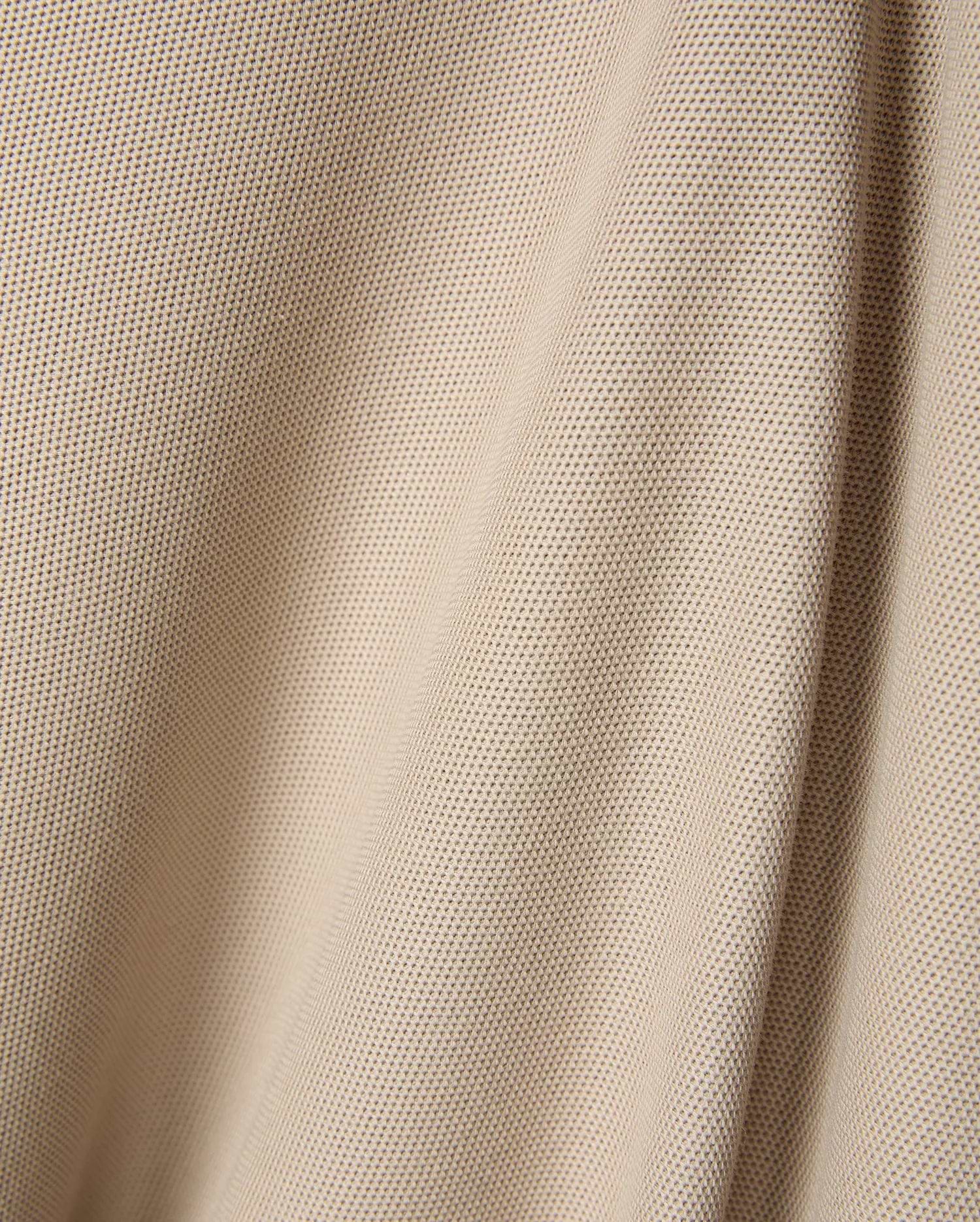 Premium beige Mens Ringston Pique Polo, showcasing a refined textured pique knit fabric, designed for a classic fit, with the iconic embroidered Psycho Bunny skull logo on the chest.