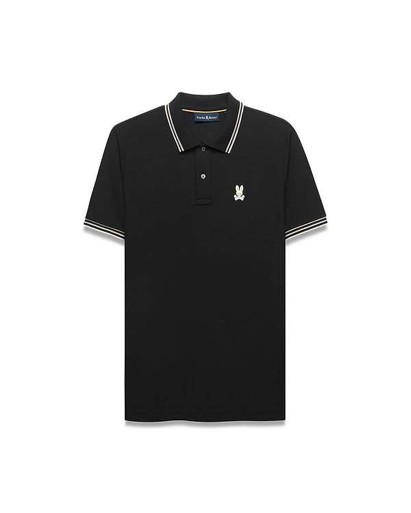 Mens Atley Pique Polo in black, featuring a classic fit, pique texture, white and gold striped collar and sleeve cuffs, and a small embroidered cream and gold Psycho Bunny skull logo on the left chest. (5)