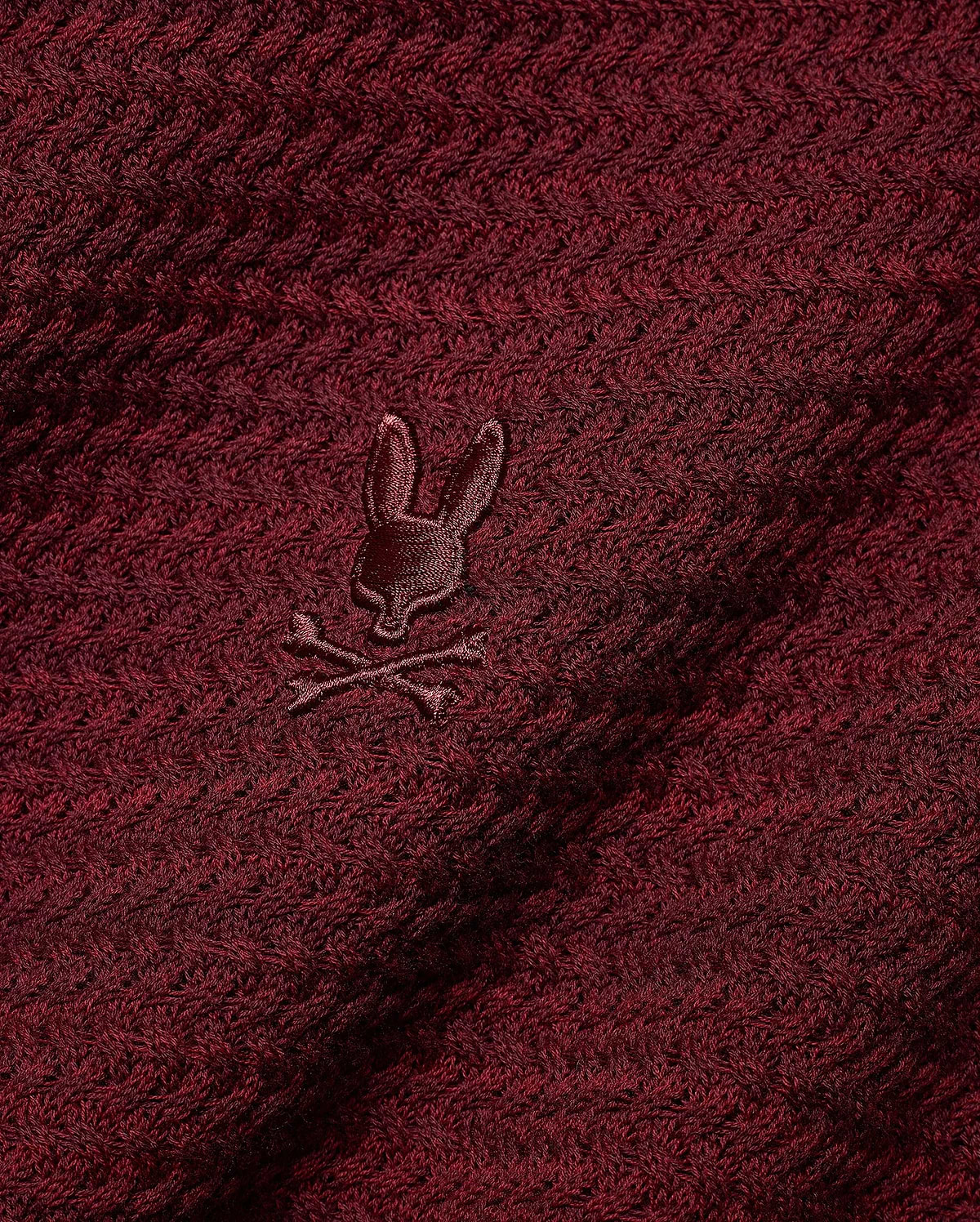 Men's Devon Braided Knit Polo in deep burgundy, featuring a rich braided knit texture and a small, tonal embroidered Psycho Bunny skull logo on the chest. (6)