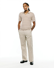 Mens Devon Braided Stitch Knit Polo in light tan, featuring a classic fit, intricate braided stitch knit texture, an open collar, and a small embroidered Psycho Bunny skull logo on the left chest.