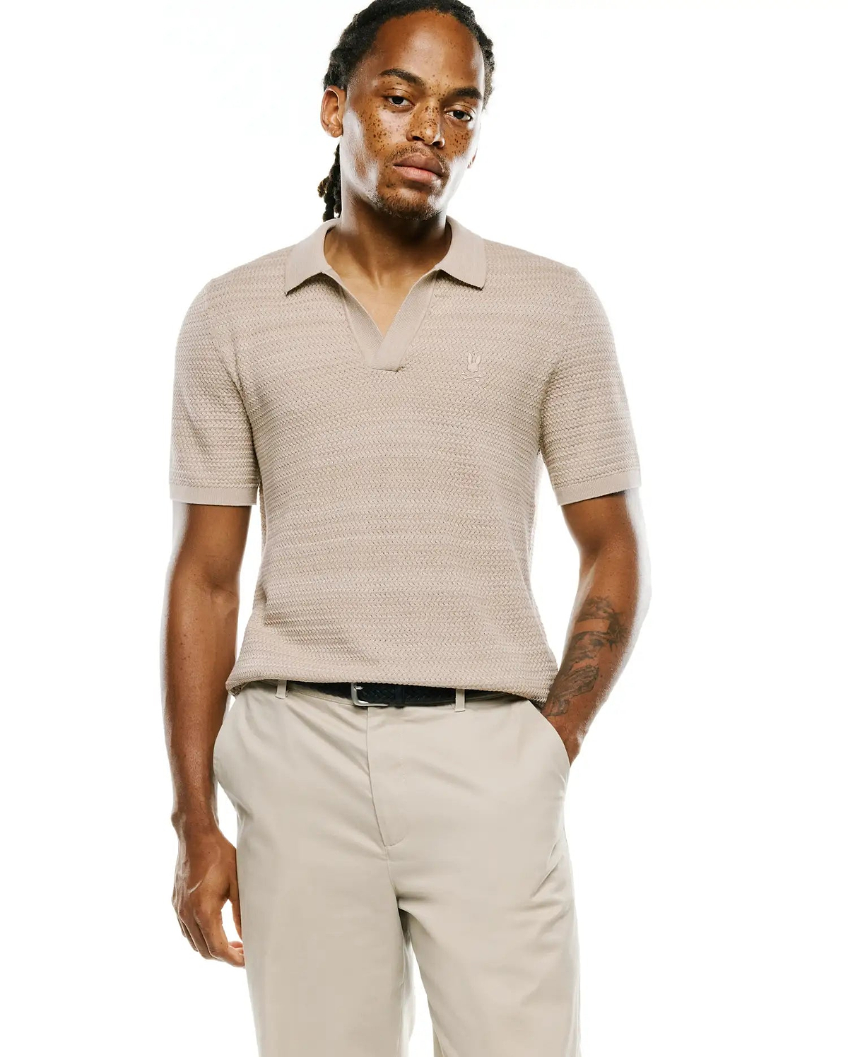 Mens Devon Braided Stitch Knit Polo in beige, featuring a classic fit, open collar, and a small embroidered Psycho Bunny skull logo on the left chest.
