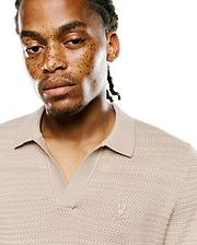 Mens Devon Braided Stitch Knit Polo in beige, featuring a unique braided stitch knit texture, spread collar, V-neck placket, and a small embroidered Psycho Bunny skull logo on the left chest.