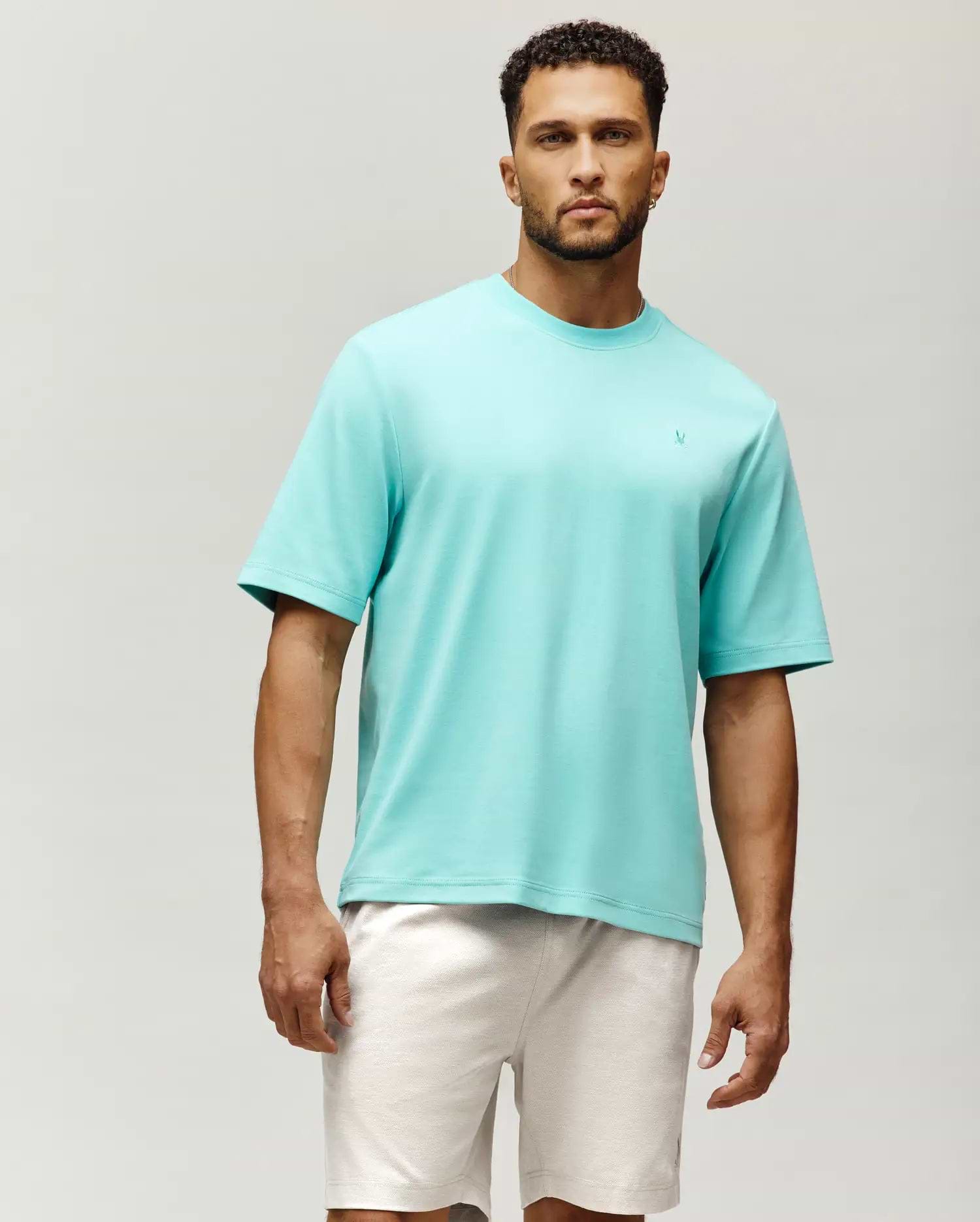 Mens Adam Interlock Tee, a vibrant aqua, relaxed fit, smooth interlock knit t-shirt featuring a small, embroidered Psycho Bunny skull logo on the left chest.