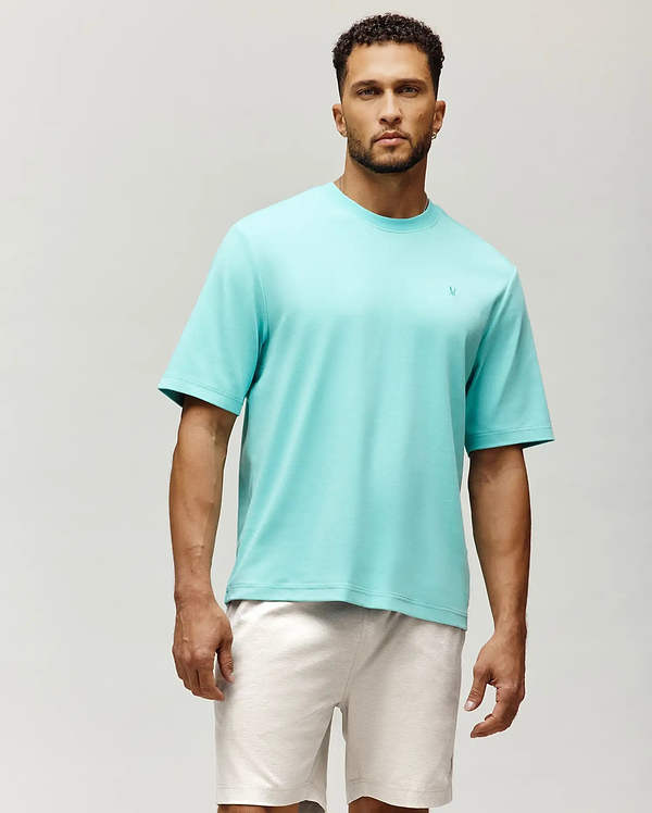 Mens Adam Interlock Tee, a vibrant aqua, relaxed fit, smooth interlock knit t-shirt featuring a small, embroidered Psycho Bunny skull logo on the left chest.