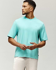 Mens Adam Interlock Tee in vibrant aqua, featuring a relaxed fit, smooth interlock knit, and a small tonal embroidered Psycho Bunny skull logo on the left chest.