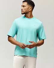 Mens Adam Interlock Tee in vibrant aqua, featuring a relaxed fit, smooth interlock knit, and a small tonal embroidered Psycho Bunny skull logo on the left chest.